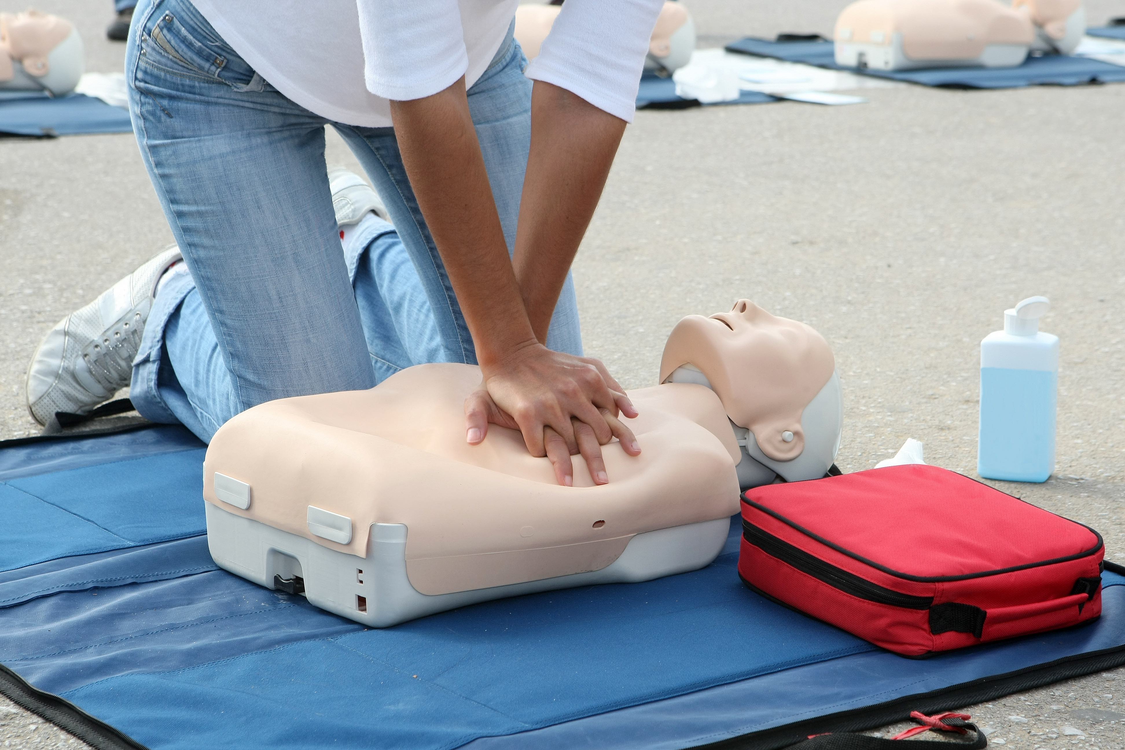Female instructor showing CPR on training doll
